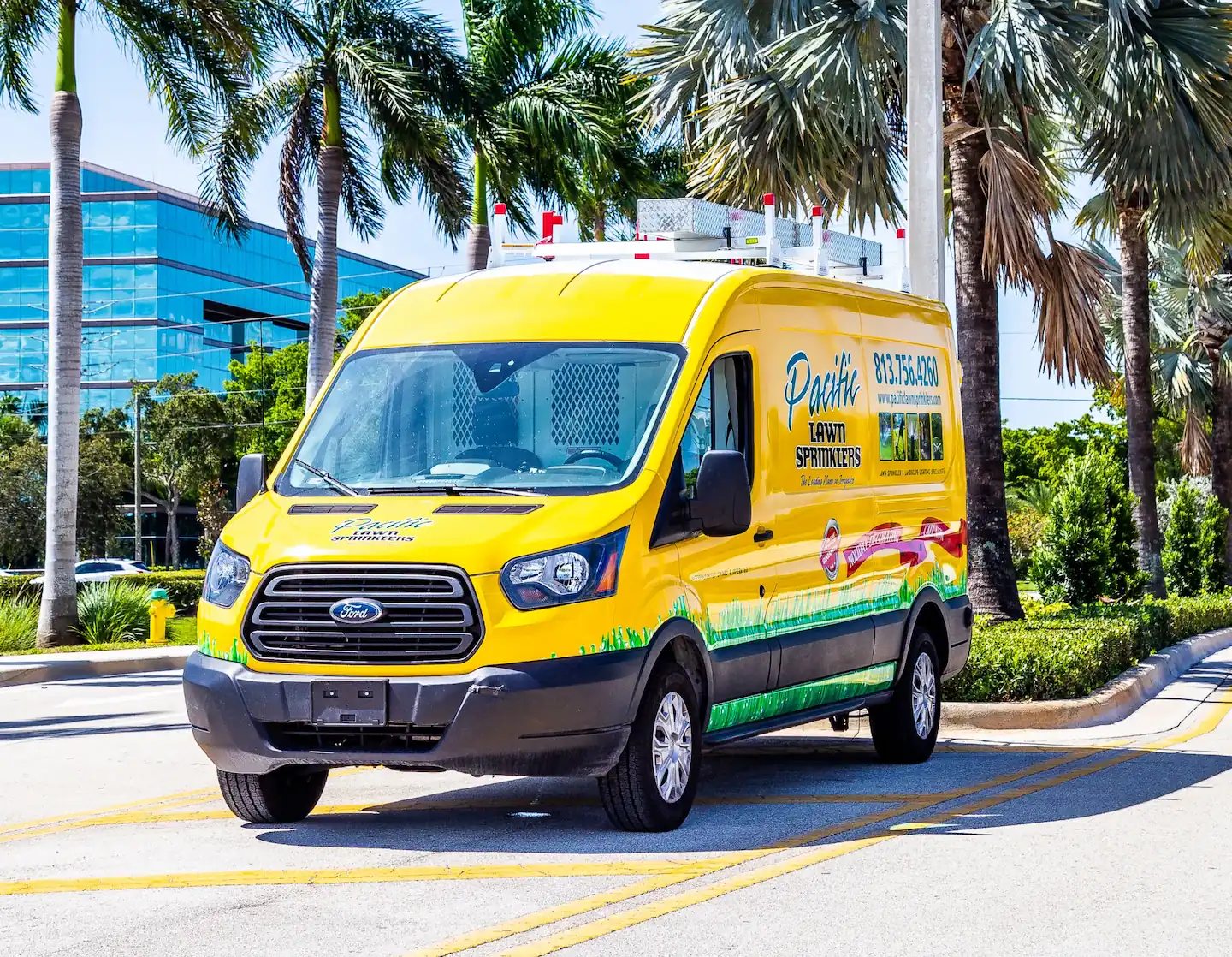 Pacific Lawn Sprinklers yellow service van parked near palm trees